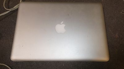 an apple laptop computer sitting on top of a table next to a charger