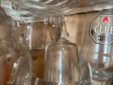 bottles and glasses are stacked on top of each other on a counter