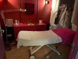 une table de massage dans une pièce dont l'un des murs est rouge