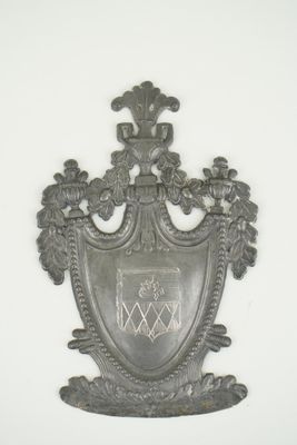 une plaque métallique sur laquelle est représenté un blason