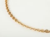 a close up of a gold chain necklace on a white surface