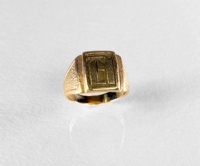 an image of a gold signet ring on a white surface