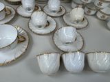 a lot of white and gold china on the table