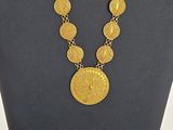 un gros plan d'un collier et d'une boucle d'oreille sur un mannequin