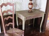 a small table with a lamp and a chair in the corner