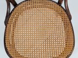 a close up of a wooden chair with a wicker seat