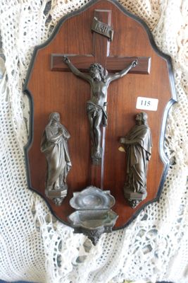 une plaque en bois sur laquelle sont représentés un crucifix et trois figurines