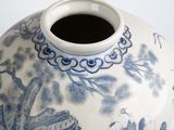 a blue and white vase sitting on a white surface