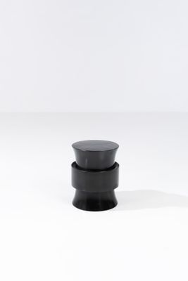 un gros plan d'un bouton noir sur une surface blanche