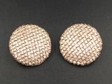 une paire de boutons en maille dorée sur un fond noir