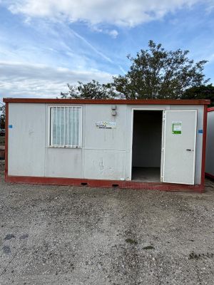 a small white and red building with a door open