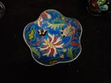 a blue bowl with flowers on it sitting on a table