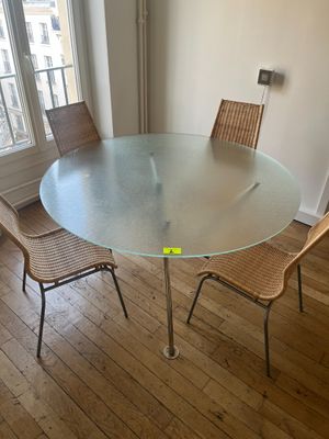 une table en verre entourée de chaises dans une pièce