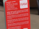 a red sign that says fam on it in front of a car