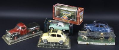 four toy cars are sitting in a display case on a black surface
