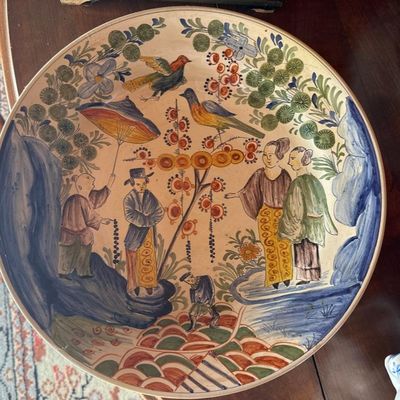 une assiette avec une peinture posée sur une table