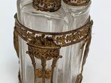 a glass jar with four bottles in it on a table