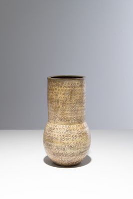 un vase marron posé sur une table blanche