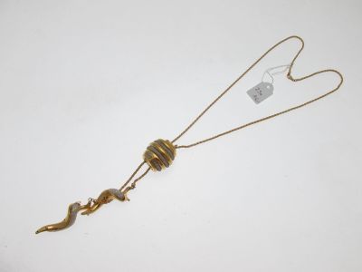 un gros plan d'un collier posé sur une surface blanche, auquel est accrochée une étiquette