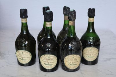 four bottles of wine are lined up on a marble surface