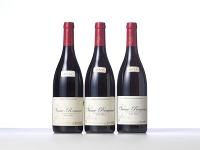 three bottles of wine are lined up on a table
