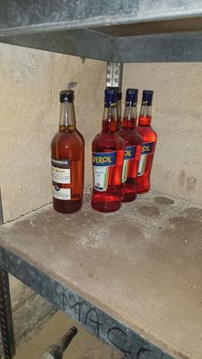 Plusieurs bouteilles d'alcool sont posées sur une étagère dans une pièce.