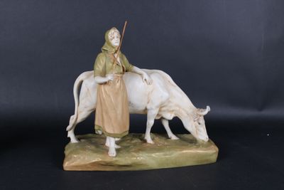 une figurine représentant une femme assise sur une vache