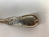 a silver spoon with a flower design on it