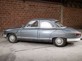 a car that is parked in a garage next to a brick wall