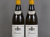two bottles of wine sitting on top of a table next to each other