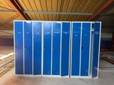 several blue metal lockers in a warehouse with a wooden ceiling
