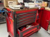 un chariot à outils rouge contenant des outils, dans un garage