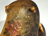 a vase with flowers painted on it sitting on a table