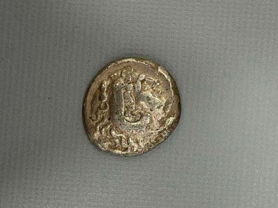 a close up of a gold coin with a face on it