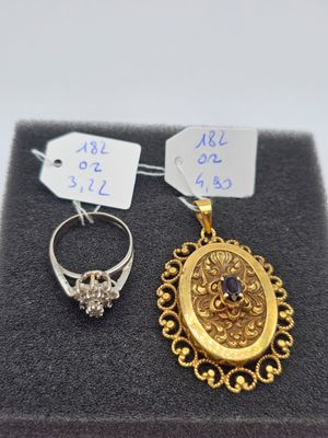 two gold rings and a diamond ring are on display in a box