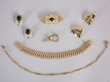 a lot of gold jewelry on a white surface