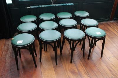 neuf tabourets posés sur un parquet devant une fenêtre