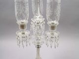 a glass candelab with three candles on top of it