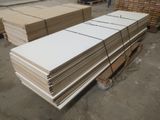 de nombreuses piles de tableaux blancs sur une palette dans un entrepôt