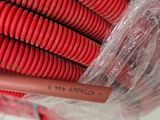 a red hose wrapped in plastic on the floor