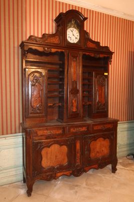 un grand meuble en bois surmonté d'une horloge