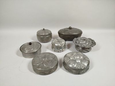several silver metal objects are sitting on a white surface