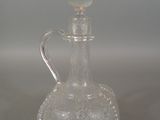 a clear glass bottle with a silver handle on a table