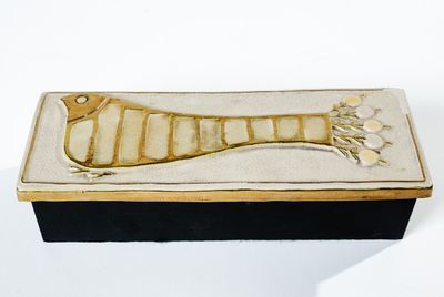 une petite boîte sur laquelle est représenté un poisson, posée sur un fond blanc
