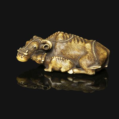an image of a sculpture of a bull laying down on a black surface