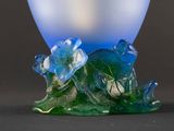 a glass vase with a flower on it on a black surface