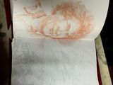 drawing of a woman ' s face on a piece of paper in a box