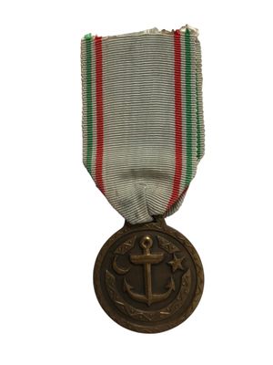 une vieille médaille entourée d'un ruban rouge, blanc et vert