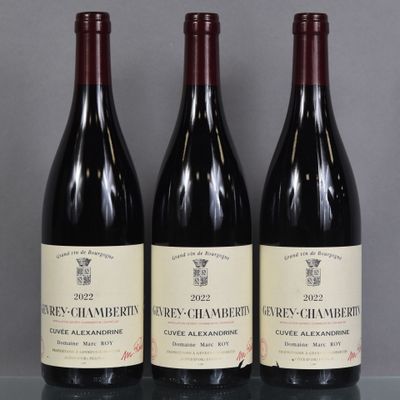 three bottles of wine are lined up on a glass table