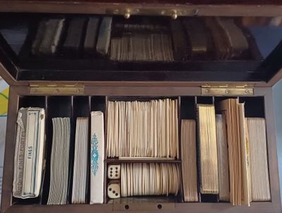 une boîte en bois remplie de nombreux dossiers et d'un jeu de dominos